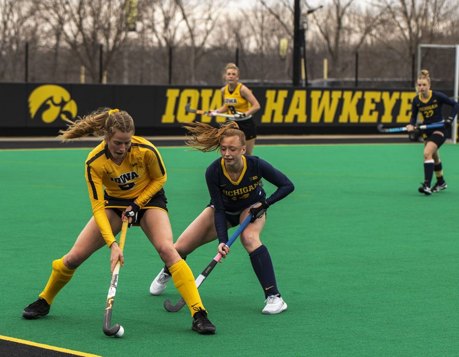 Iowa Midfielder Sofie Stribos works to move the ball, while a Michigan player tries to stop her during a field hockey game between Iowa and Michigan at Grant Field on Saturday, March 15, 2021. The Hawkeyes defeated the Wolverines, 2-1, in a shootout.