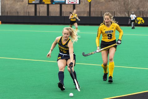Michigan Midfielder Sarah Pyrtek moves the ball upfield as Iowa Midfielder Sofie Stribos moves in during a field hockey game between Iowa and Michigan at Grant Field on Saturday, March 15, 2021. “The Hawkeyes defeated the Wolverines, 2-1, in a shootout.”(Jeff Sigmund/Daily Iowan)