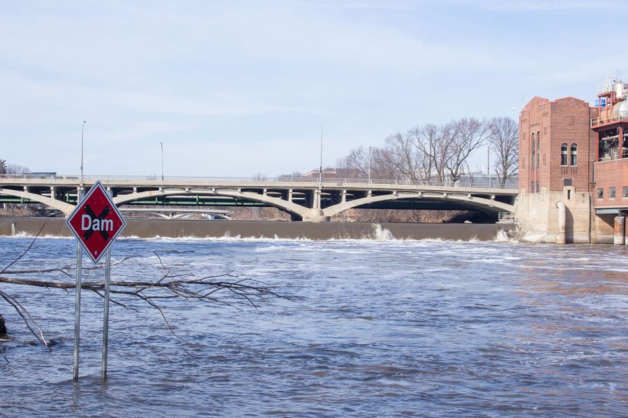 A sign warning of a dam upstream is seen in high waters in the Iowa River on March 8. (Ayrton Breckenridge/The Daily Iowan)