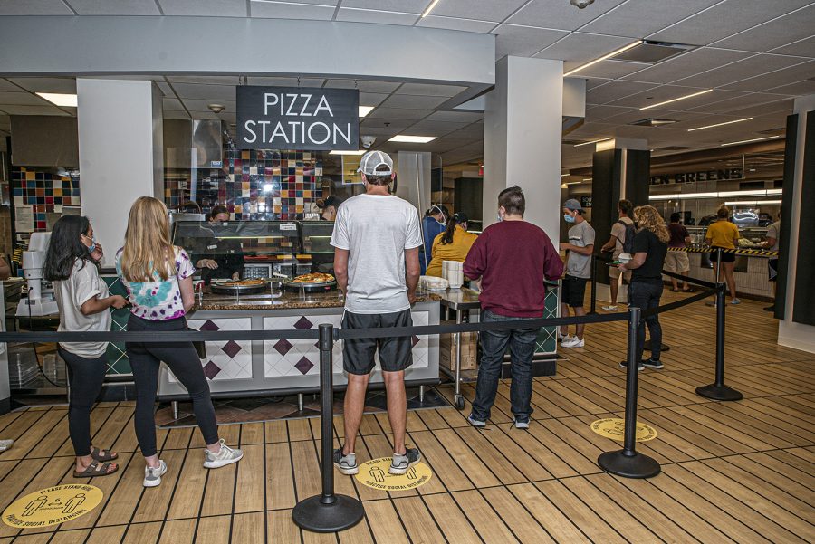 A Burge Market Place worker serves a line of students on Monday, August 26th, 2020. Due to health and safety regulations as a means of preventing the spread of COVID-19, the dining hall process has been streamlined with an advanced registration process and a takeout meal process.