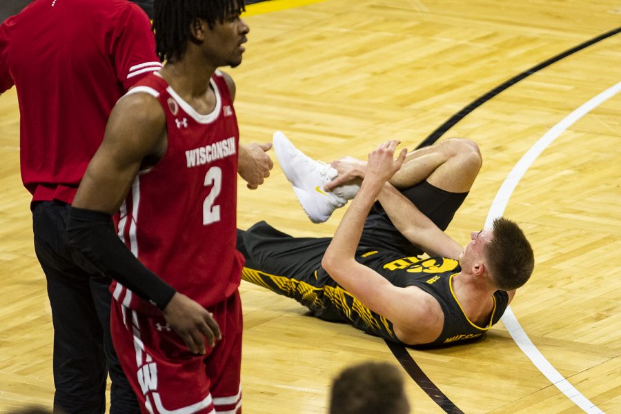 Iowa guard Joe Wieskamp grabs at his right leg during a menÕs basketball game between Iowa and Wisconsin at Carver-Hawkeye Arena on Sunday, March 7, 2021.