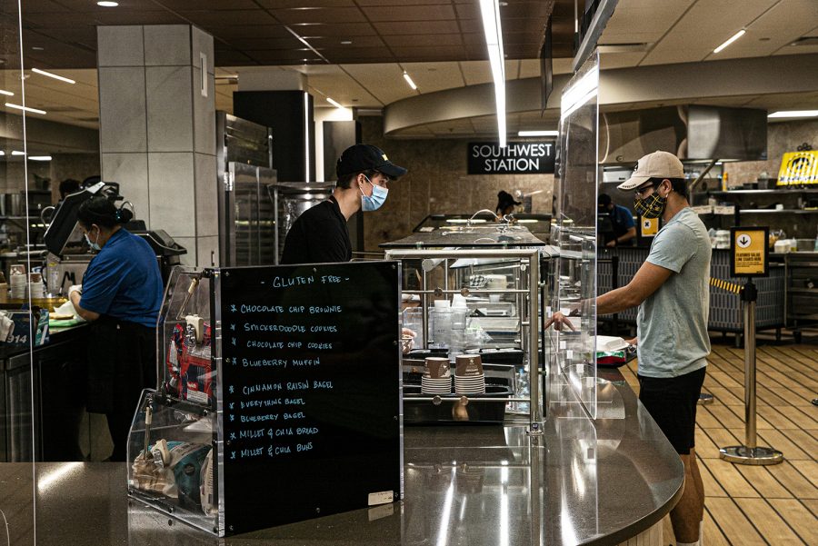A Burge Marketplace worker serves a line of students on Monday, August 26th, 2020. Due to health and safety regulations as a means of preventing the spread of COVID-19, the dining hall process has been streamlined with an advanced registration process and a takeout meal process. 