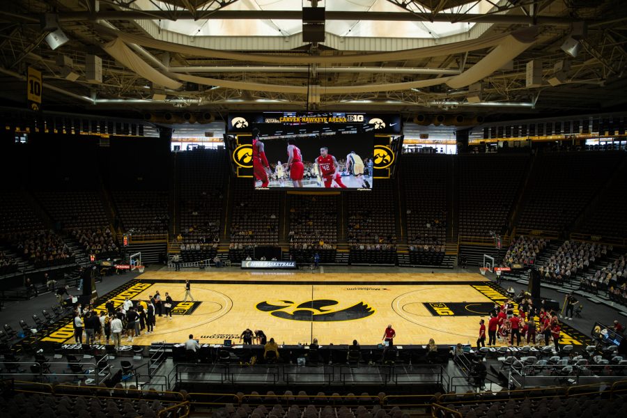 Teams huddle during a timeout during a mens basketball game between Iowa and Wisconsin at Carver-Hawkeye Arena on Sunday, March 7, 2021. The Hawkeyes, celebrating senior day, defeated the Badgers, 77-73.