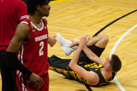 Iowas Joe Wieskamp lays injured on the ground during a mens basketball game between Iowa and Wisconsin at Carver-Hawkeye Arena on Sunday, March 7, 2021. The Hawkeyes, celebrating senior day, defeated the Badgers, 77-73. (Shivansh Ahuja/The Daily Iowan)