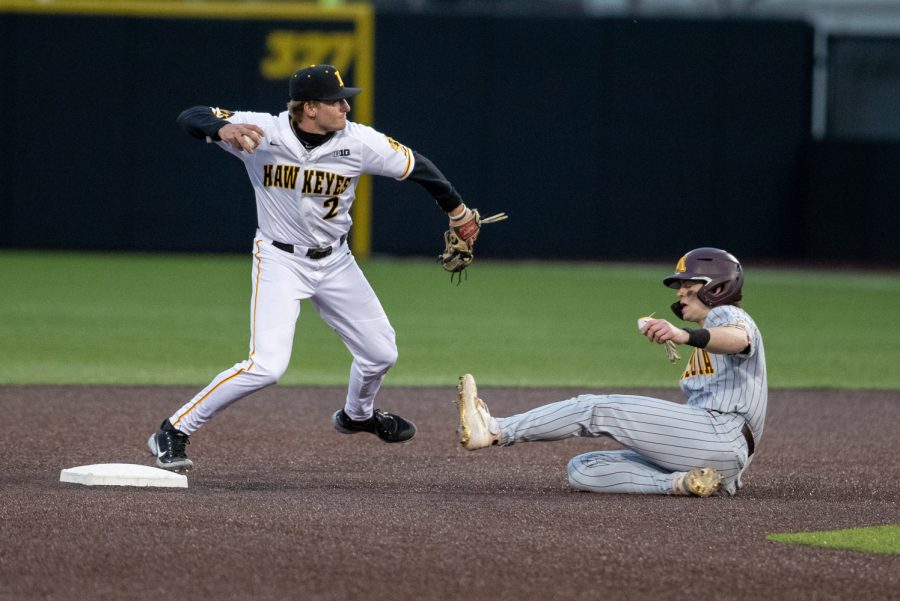 Iowa shortstop Brendan Sher throws to first after tagging second for a double play during a baseball game between Iowa and Minnesota at Duane Banks Field on April 9, 2021. The Hawkeyes defeated the Gophers 7-0.