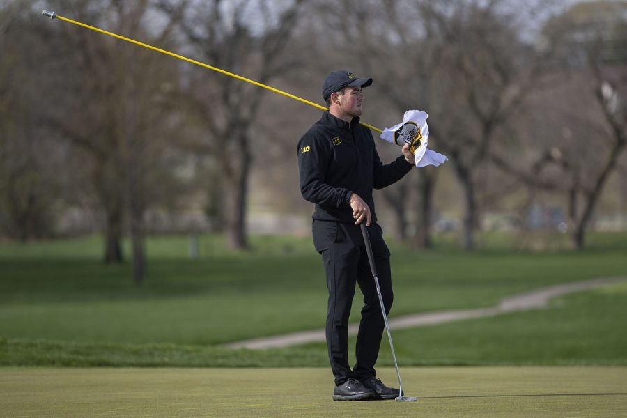 Iowas Mac McClear holds the flag during the mens golf Hawkeye Invitational on Saturday, April 17, 2021 at Finkbine Golf Course.