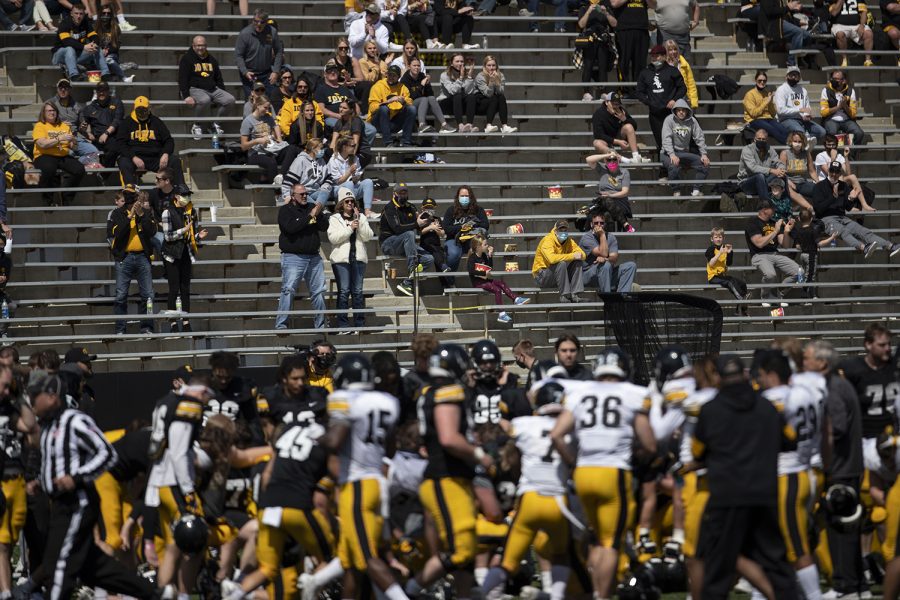 Fans watch as the Hawkeyes huddle after Iowa football spring practice on Saturday, April 17, 2021 in Kinnick Stadium.