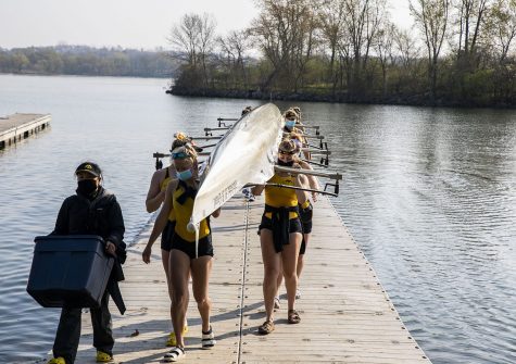 The Hawkeyes carry the boat back to their team area on Saturday, April 24, 2021. Team 2 Novice 8 won their race with a time of 7:14.50.