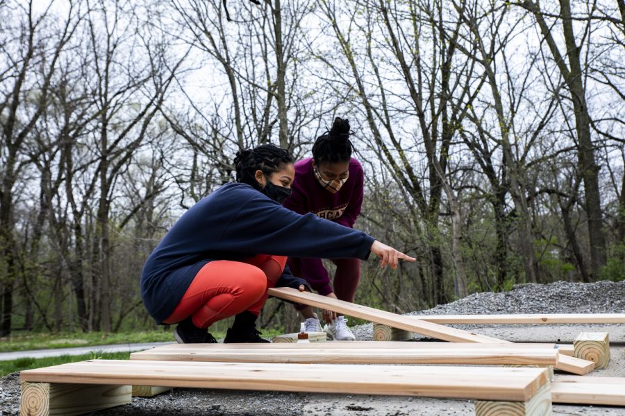 Aluna-Aro Olaniyi (left) and Cherish Cornett (right) discuss how to lay out the boards for the design of the boxes on Sunday, April 11, 2021. The boxes will be used to grow vegetables in a community garden located behind the Afro-House. 