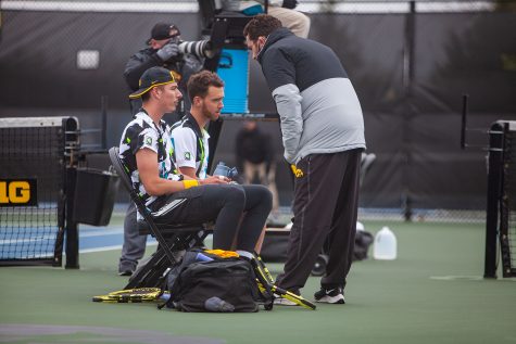 Iowa’s Nikita Snezhko (left) and Kareem Allaf (middle) listen to head coach Ross Wilson (right) during a men’s tennis meet between Iowa and Northwestern on Sunday, April 11 at the Hawkeye Tennis and Recreation Complex. The Wildcats defeated the Hawkeyes 6-1. 