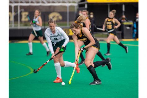 Iowa Midfielder Ellie Holley works past a defender during a field hockey game between Iowa and Michigan State at Grant Field on Friday, March 26, 2021. The Hawkeyes defeated the Spartans 5-0. 