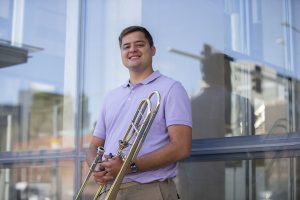 Masters student studying trombone performance, Ben Hahn, poses for a portrait outside of Voxman Music Building at the University of Iowa. Hahn is a finalist for an international solo competition organized by the International Trombone Association, and will be playing in the final round this summer. 