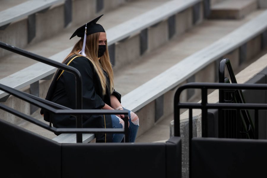 A 2021 graduate sits alone with a mask on during the University of Iowa’s celebration of graduates Sunday, May 16, 2021, at Kinnick Stadium. (Kate Heston/The Daily Iowan)