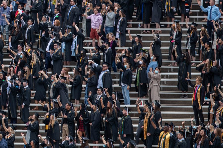 Graduates take part in the “Iowa Wave,” a tradition in which fans wave to children at the children’s hospital, during the University of Iowa’s celebration of graduates Sunday, May 16, 2021, at Kinnick Stadium. (Kate Heston/The Daily Iowan)
