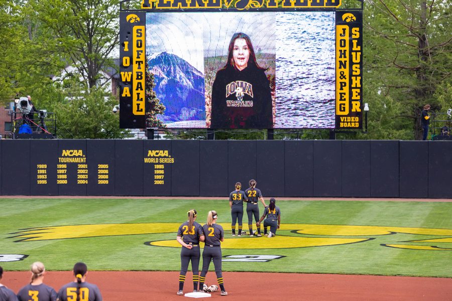 The Iowa Hawkeyes listen to the National Anthem sung by a future Hawkeye before the start of the Iowa Softball game against Illinois on May 14, 2021 at Bob Pearl Field. Iowa defeated Illinois 3-1. 