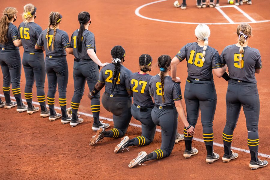 The Iowa Hawkeyes listen to the National Anthem sung by a future Hawkeye before the start of the Iowa Softball game against Illinois on May 14, 2021 at Bob Pearl Field. Iowa defeated Illinois 3-1. 