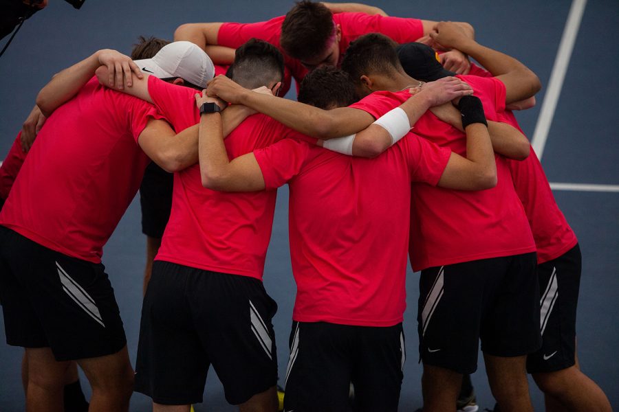 The Iowa’s mens tennis team huddles during their meet v. Nebraska at the Hawkeye Tennis and Recreation Complex on Sunday, Feb. 28. The Hawkeyes defeated the Huskers with a score of 5-2. The team wears red, instead of the team colors, to protest the University of Iowa’s decision to cut their program, making it their final season.