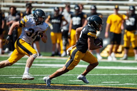 Iowa linebacker Jack Campbell (left) chases after Iowa wide receiver Keagan Johnson (right) during a spring practice at Kinnick Stadium on Saturday, May 1, 2021.