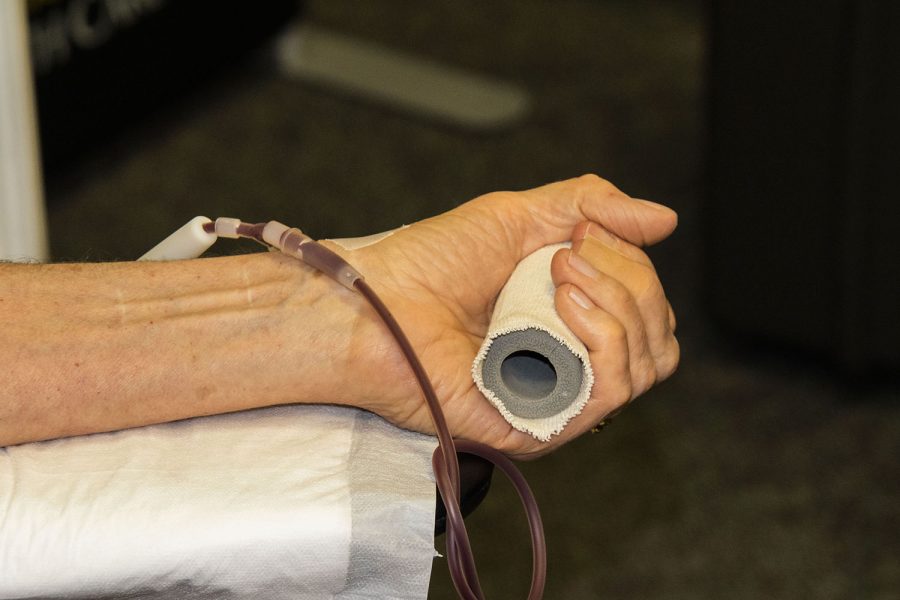 A blood donor squeezes a device to help blood flow on Friday, June 25, 2021. 