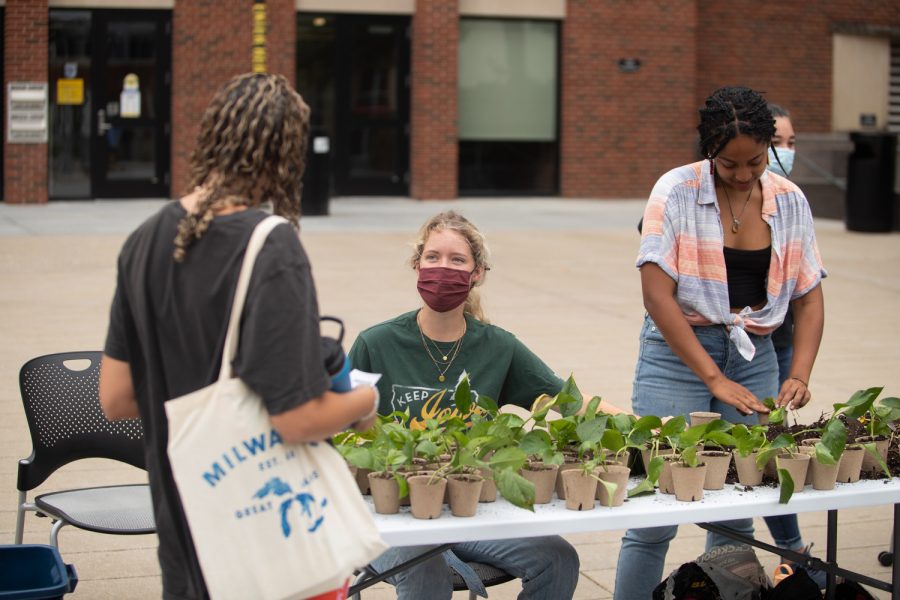 University of Iowa junior Katey Namanny talks to a student about caring for her new plant outside the Main Library on Aug. 31, 2021. 