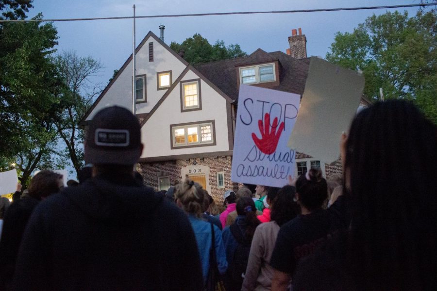 People stand in front of Phi Gamma Delta during a protest following sexual assault allegations against the University of Iowa’s chapter of Phi Gamma Delta on Tuesday, Aug. 31, 2021.