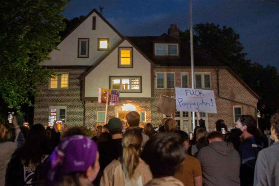 People stand in front Phi Gamma Delta during a protest following sexual assault allegations against the University of Iowa’s chapter of Phi Gamma Delta on Tuesday Aug. 31, 2021.
