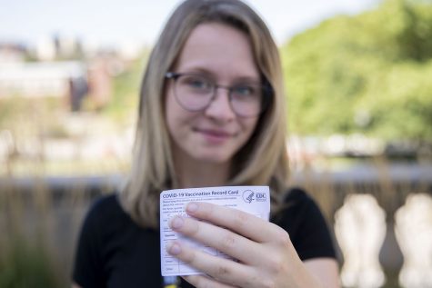 First-year Jenna Sackett poses with her vaccination card on the Pentacrest at the University of Iowa on Tuesday, Aug. 24, 2021. 