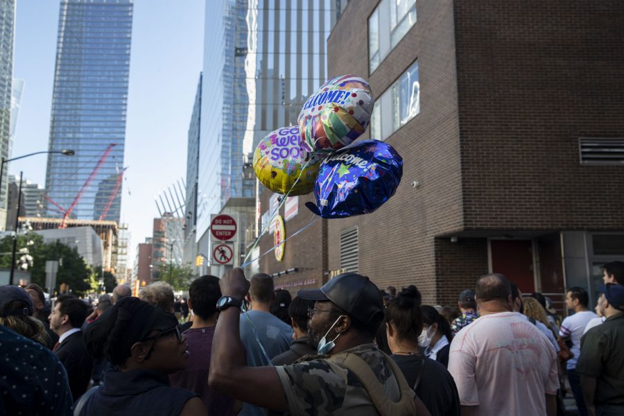 A spectator holds up balloons saying “Get Well Soon” and “Welcome” outside of the 9/11 Memorial in New York City on the 20th anniversary of the 9/11 attacks. 