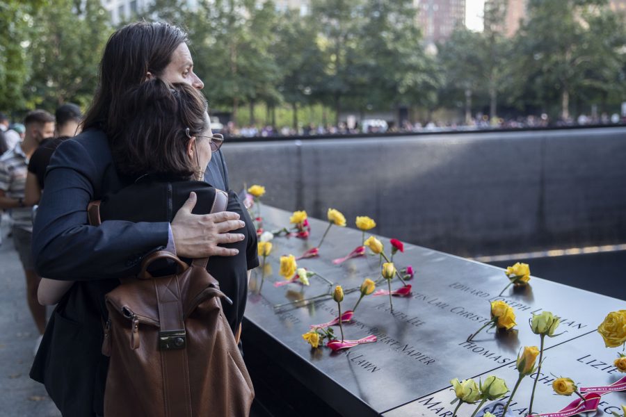 Two spectators are seen hugging at the 9/11 Memorial in New York City on Saturday, Sept.11, 2021, the 20th anniversary of the 9/11 attacks. 