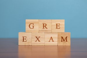 Concept of GRE Exam in wooden block letters on table. 