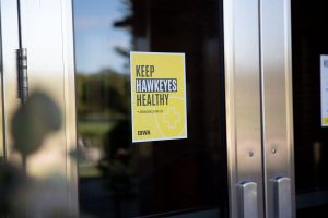 A COVID-19 safety sign hangs on the door of the Adler Journalism Building in Iowa City on Thursday, Sept. 23, 2021. 