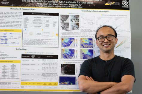 University of Iowa graduate research assistant Meng Zhou poses in front of his research Wednesday, Sept. 15, 2021. 