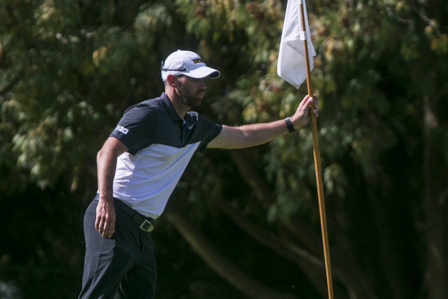 Iowa head coach Tyler Stith grabs a flag out of the 18th hole during a tournament at the Donald Ross Course at the Cedar Rapids Country Club in Cedar Rapids on Tuesday, Sept. 19, 2017. 