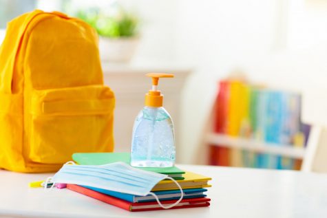 Backpack of school child with face mask and sanitizer. 
