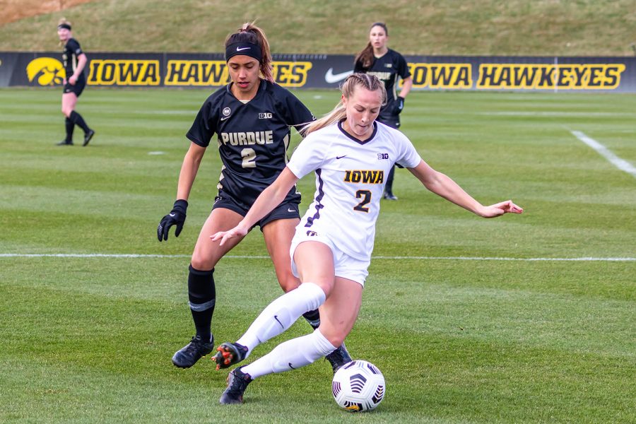 Iowa Midfielder Hailey Rydberg moves the ball away from Purdue Defender Julia Ware during the Iowa Soccer senior day game against Purdue on Mar. 28, 2021 at the Iowa Soccer Complex. Iowa defeated Purdue 1-0. 