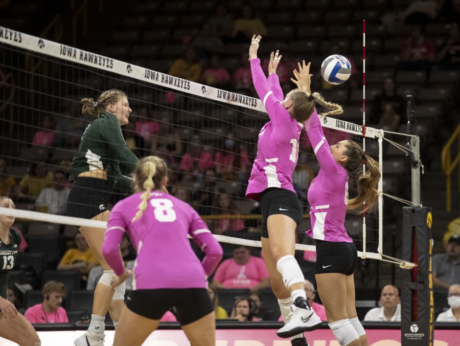 Iowa middle back Bltyhe Rients and setter Jenna Splitt attempt to block the ball during a volleyball game between Iowa and Michigan State at the Carver Hawkeye Arena on Oct. 1, 2021. The Trojans defeated the Hawkeyes 3 sets to 0.
