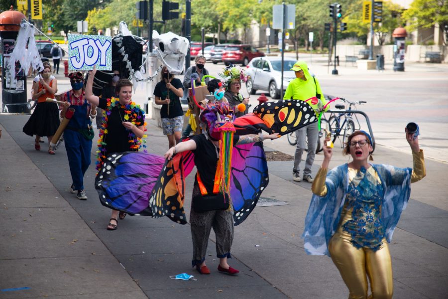 Community members march down the sidewalk during the Joy March in downtown Iowa City Saturday, Oct. 2, 2021. Every four months, community members come together to celebrate and spread joy in unique costumes.
