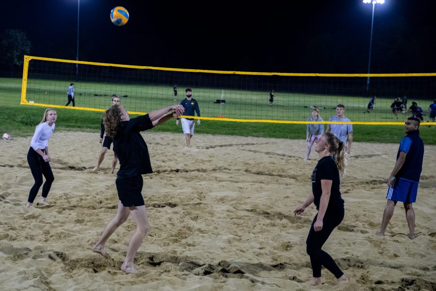 Students play volleyball at the Hawkeyes Recreational Sand Volleyball Courts on Wednesday, Oct. 21, 2021. Every Wednesday, they come together to the sand courts to play volleyball. 