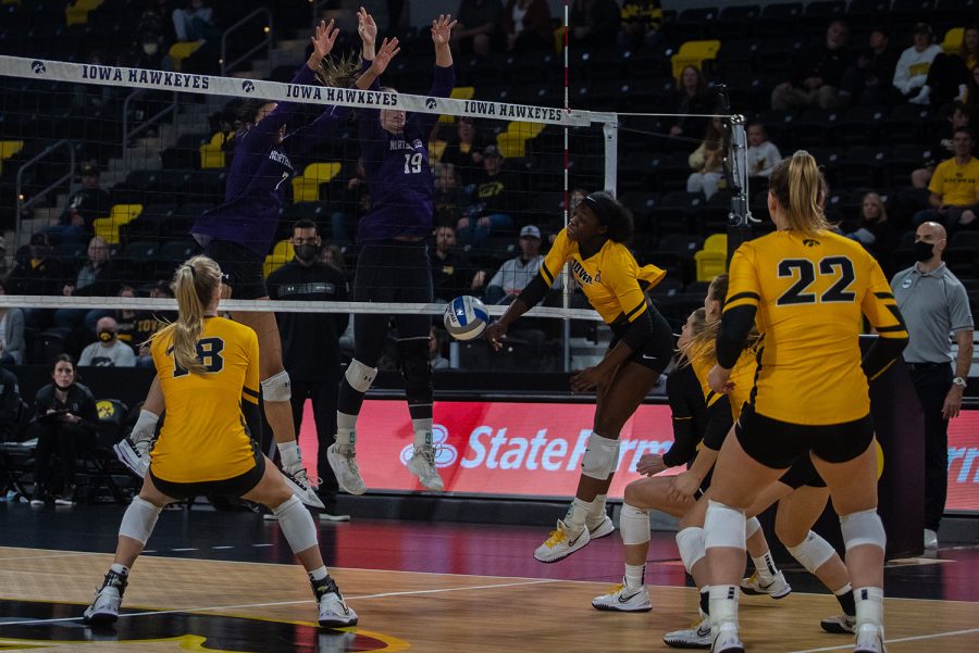 Northwestern outside hitter Hanna Lesiak and middle blocker Leilani Dodson block a spike from Iowa middle blocker Toyosi Onabanjo during a volleyball match at Xtream Arena in Iowa City on Saturday, Oct. 16, 2021. The Wildcats defeated the Hawkeyes 3-0. (Larry Phan/The Daily Iowan)