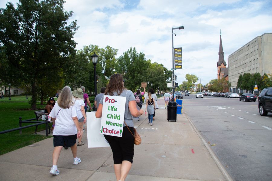 Women’s rights activists walk down South Clinton Street during a women’s march in Iowa City on Saturday, Oct. 2, 2021. The march encountered both street preachers and members of the Iowa City community celebrating Pride. 