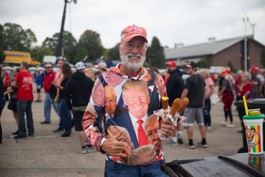 An attendee poses with three corn dogs prior to Donald Trump’s “Save America” rally in Des Moines, Iowa on Saturday, Oct. 9, 2021. Two venders were in charge of feeding the thousands of attendees that showed up for Trump’s rally.