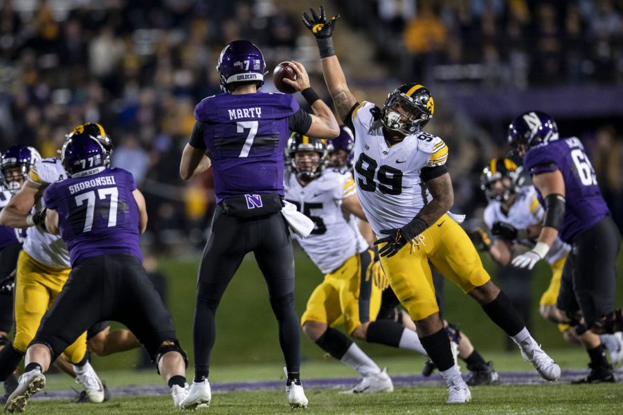 Iowa defense end Noah Shannon attempts to block a pass by Northwestern quarterback Andrew Marty during a football game between No. 19 Iowa and Northwestern at Ryan Field in Evanston, Illinois, on Saturday, Nov. 6, 2021. 