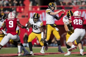 Iowa running back Tyler Goodson rushes the ball as quarterback Spencer Petras fakes a pass during a football game between No. 16 Iowa and Nebraska at Memorial Stadium in Lincoln, Nebraska, on Friday, Nov. 26, 2021. The Hawkeyes defeated the Corn Huskers 28-21. (Grace Smith/The Daily Iowan)