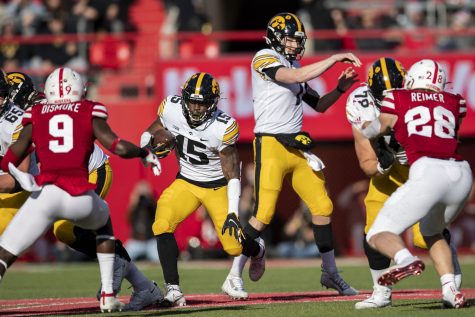 Iowa running back Tyler Goodson rushes the ball as quarterback Spencer Petras fakes a pass during a football game between No. 16 Iowa and Nebraska at Memorial Stadium in Lincoln, Nebraska, on Friday, Nov. 26, 2021. The Hawkeyes defeated the Corn Huskers 28-21. (Grace Smith/The Daily Iowan)