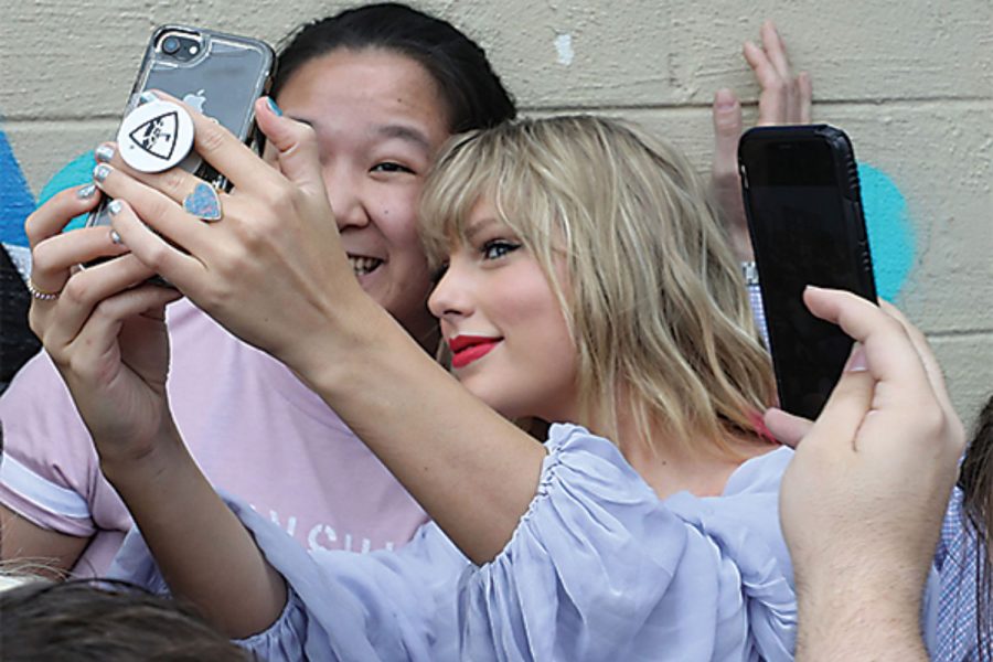 Taylor Swift takes a selfie with fans at an appearance at a butterfly mural in the Gulch in Nashville, Tenn., on Thursday, April 25, 2019. (Alan Poizner/For The Tennessean)