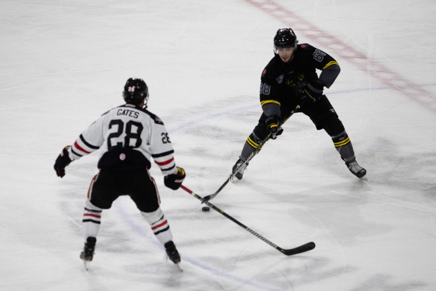 Iowa defenseman Billy Constantinou attempts to get the puck by Indy forward Brent Gates during a hockey game between the Iowa Heartlanders and Indy Fuel at the Xtream Arena in Coralville, Iowa on Friday, Nov. 12, 2021. Iowa won 5-3. 
