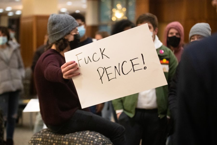 A protester holds a sign at a protest against former Vice President Mike Pence in the IMU at the University of Iowa Monday, Oct. 11, 2021. 