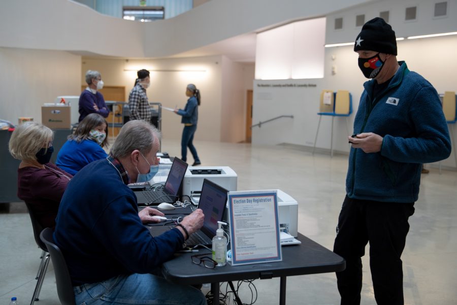 Poll workers help voters on Election Day at the Visual Arts Building in Iowa City on Monday, Nov. 1, 2021. 