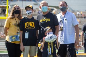 Iowa kid captain Lucas Moore and family pose with head coach Kirk Ferentz during “Kid’s Day at Kinnick” inside Kinnick Stadium on Saturday, Aug. 14. 