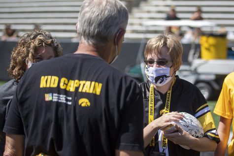 Kid captain Bridgette Bissell talks with head coach Kirk Ferentz after receiving a signed football from the team during “Kid’s Day at Kinnick” inside Kinnick Stadium on Saturday, Aug. 14. 